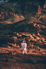 Astronaut exploring a new planet. Searching for a new home for humanity. Concept about science and nature © oneinchpunch