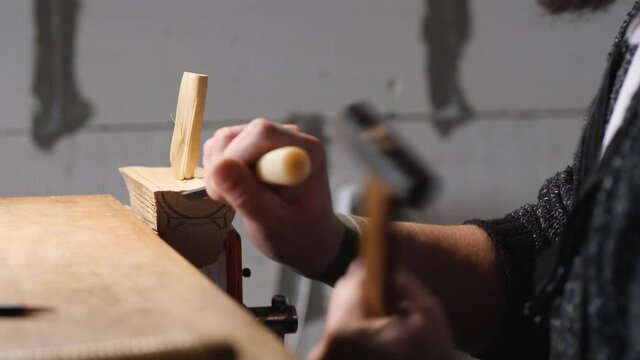 woodcarver carves poplar tea leaves holder with chisel and hammer. the art of woodworking. handmade concept