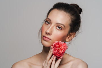 Beautiful half-naked woman posing with flower on camera
