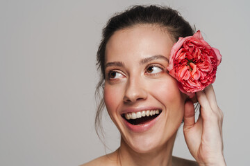 Smiling half-naked woman posing with flower on camera