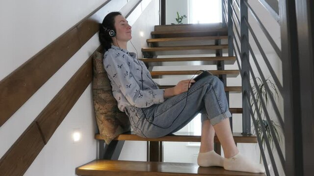 Woman relaxing with eyes closed wearing headphones