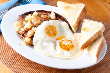 two eggs over easy, sausage, hashbrowns and toast