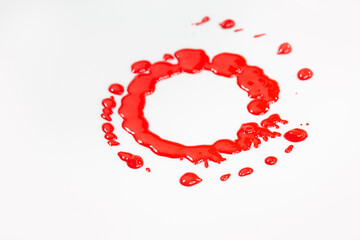 .Red ink dripping circles on the ground of a rotating white object.