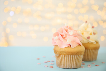 Tasty cupcakes on table against blurred lights, space for text. Valentine's Day celebration