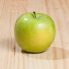 Tasty green apple; photo on wooden background.
