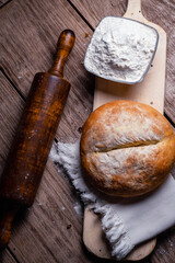 close-up of rolling pin for rolling and flattening dough flour freshly made hot homemade bread on wooden base cordoba argentina
