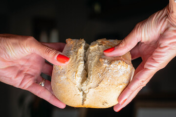 Hot homemade bread with moisture vapor freshly made in a Chilean clay oven with white flour and women's hands Cordoba Argentina