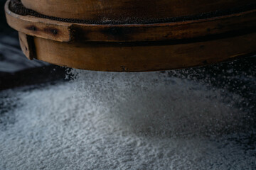 Fototapeta premium flour falls in the form of snow on mountain with sifter with black background cordoba argentina