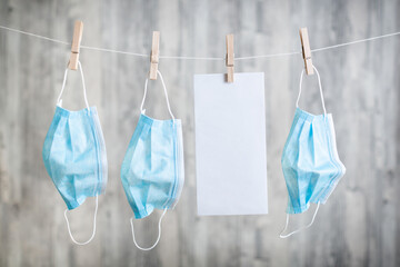 auf einer W&auml;scheleine befestigte Masken mit einem Platzhalter f&uuml;r Text, l&auml;nglich, Hochformat, Corona 