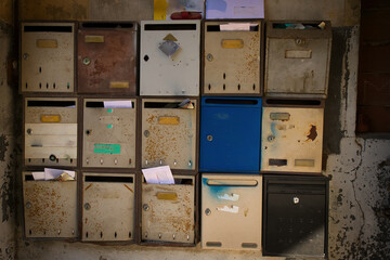 photo of rusty mailboxes in an entrance to a poor residence.