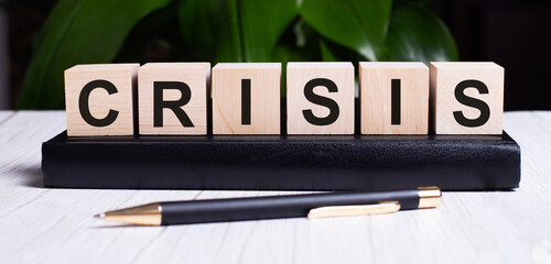 The word CRISIS is written on the wooden cubes of the diary near the handle.