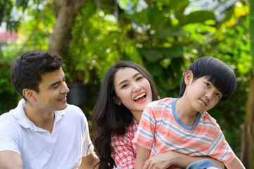 Obraz premium A happy young family spends time playing together in the garden at the front of house the vacation.