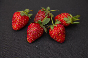 fresh large berries of garden strawberries lie on a dark background