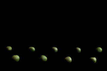 Green peas on the black background