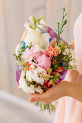 First dahlias, gladiolus, carnation, chrysanthemum and garden roses Young woman holding a beautiful bouquet in her hands on March 8
