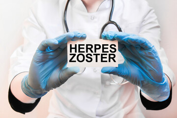 The doctor's blue - gloved hands show the word HERPES ZOSTER - . a gloved hand on a white background. Medical concept. the medicine