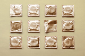 pattern of many condoms and empty package on beige background