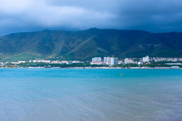 Lonely surfer in the sea against the backdrop of mountains