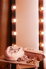 Composition with vacuum apparatus for massage therapy, towels and dry flowers above mirror with lights