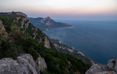 Mediterranean landscape. Forested rocks of the Black Sea coast of the southern coast of the Crimean peninsula at sunset.