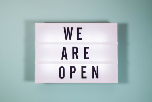 Light box with text WE ARE OPEN, top view with copy space. Reopening after covid-19 shutdown concept.