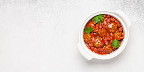 Meat or vegetable meatballs in tomato sauce with beans. Top view.