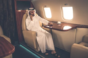 Türaufkleber Business man from united arab emirates flying on his private jet to Dubai © oneinchpunch