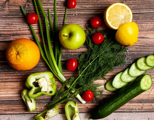 cucumber, tomatoes, pepper, orange, lemon and Apple are on the wooden table