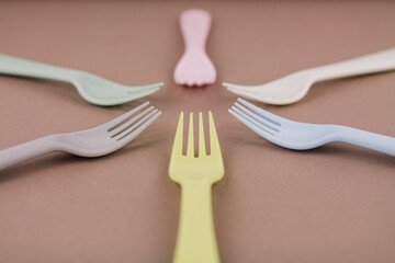 set of plastic cutlery in different colors spoons forks knives on the kitchen table and...