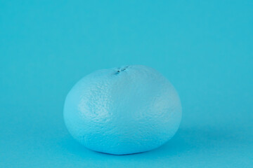 Turquoise tangerine on a turquoise background. Fake and disguise concept