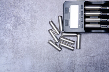 Charger and batteries energy equipment on gray concrete background, top view space for text