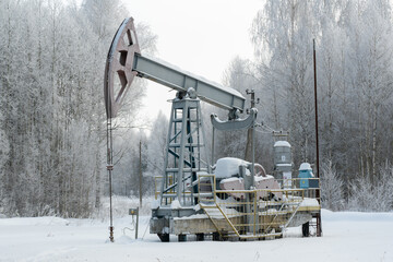 Oil rocking chair, winter landscape in Russia. Petroleum production in winter
