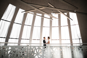 Gorgeous happy couple standing close to each other and looking in eyes