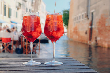 Two glasses of Spritz Veneziano cocktail served near the Venetian canal.  Popular italian summer...