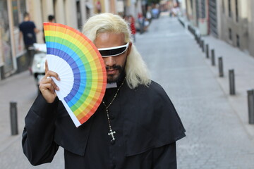 Proud and fashionable priest holding rainbow flag
