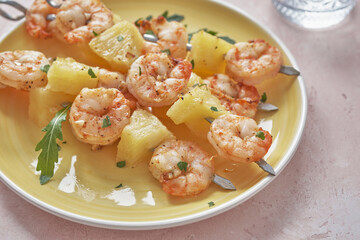 skewers of barbecued shrimp with a pineapple