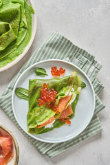 Green spinach crepes with smoked salmon, red caviar and yogurt sauce