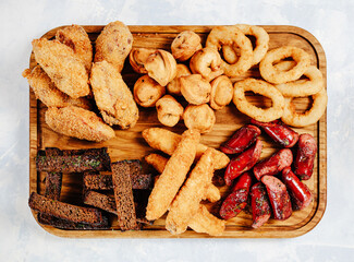 fried snacks on a wooden board top view on a blue background