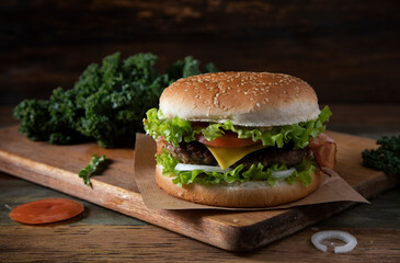 Homemade hamburger with bacon on a rustic table