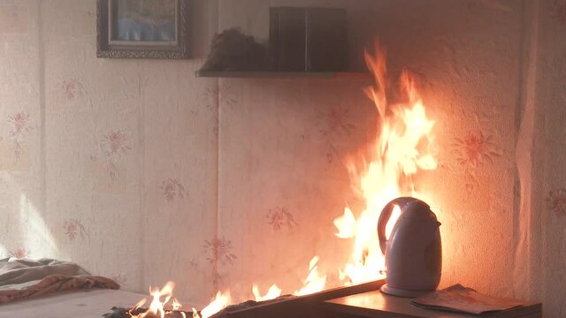 The bedroom is on fire with a lot of smoke. The bed, bedside table, plastic teapot, wallpaper and bookshelves are in flames in a residential home. Cinematic shot of aftermath of a two alarm fire 4k