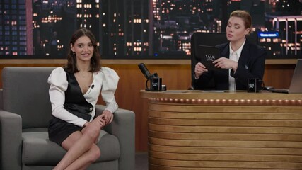Late-night talk show female host having a funny conversation with celebrity guest in a studio. TV broadcast style show. Shot with RED cinema camera