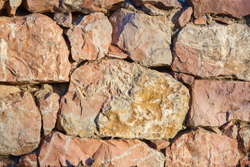Wall made of brown stones. Stone textured wallpaper