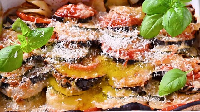 Traditional italian food. Baked eggplant, tomatoes with sauce, parmesan and basil. Rustic food for a healthy diet. Vegetables for lunch.	