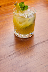 Fruit mixology with pineapple garnish on the wooden table. Warm yellow cocktails
