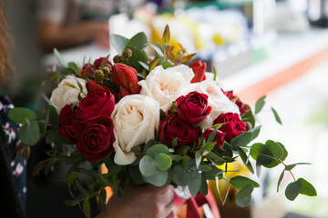 a beautiful and expensive bouquet with red and white roses and eucalyptus greens and raspberries