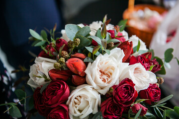 a beautiful and expensive bouquet with red and white roses and eucalyptus greens and raspberries