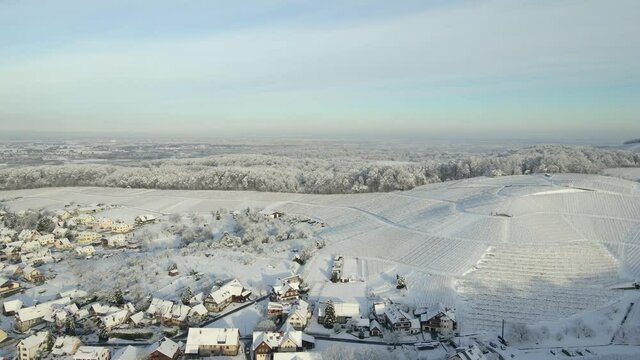 Snowy Vineyards In Hilly Landscape With Townscape Near Offenburg, Baden-Wuerttemberg, Germany, Europe. - Aerial Panning Shot