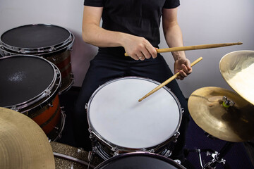 Professional drum set closeup. Man drummer with drumsticks playing drums and cymbals, on the live...