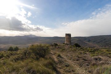Fototapeta na wymiar Islamic watchtower of Arrebatacapas on a hill in the Sierra de Guadarrama (Madrid), around which the village of Torrelaguna is located.