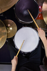 Professional drum set closeup. Man drummer with drumsticks playing drums and cymbals, on the live...